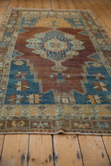 Distressed vintage Oushak rug runner border, with faded blue, copper, and ivory geometric patterns.