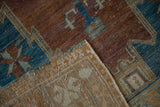 Folded corner of distressed Oushak runner showing worn copper blue pile and woven foundation.