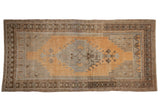 Distressed vintage Oushak runner with gold, silver, beige, and coffee brown stepped medallion.