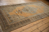 Distressed Oushak runner border with ochre, brown geometric patterns and visible even wear.