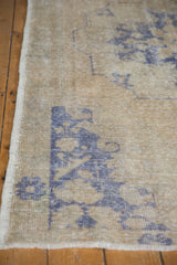 Intact side selvage and worn pile texture of the distressed vintage Oushak rug.