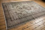 Distressed chocolate brown and beige patterns on vintage Oushak carpet border.