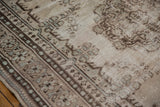 Distressed Oushak carpet showing worn pile, chocolate, and silver plant motifs.