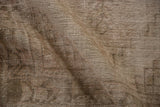 Distressed Oushak rug texture revealing worn pile, visible foundation, and subtle beige hues.