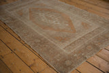 Even wear visible on the distressed surface of copper and pale brown Oushak rug.