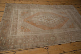 Distressed Oushak rug with intricate geometric floral border and stepped corner details.