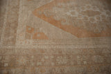 Distressed Oushak rug corner, geometric floral vine border and stepped pattern.