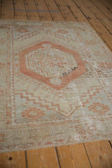 Distressed Oushak rug detail: beige field, terra cotta stepped medallion, hook-and-latch motifs.