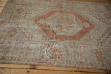 Distressed vintage Oushak rug showing worn pile, exposed foundation, and floral motif.