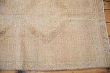Texture of vintage distressed Oushak runner, with mostly even wear across knot heads in neutral tones.