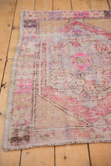 Distressed Oushak rug corner, highlighting foundation wear, intact selvage, and pale pink.