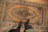 Vintage Distressed Oushak rug with oversized stepped medallion and even wear to knot heads.