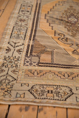 Distressed vintage Oushak rug detail: geometric border, stepped medallion, gold, ivory, charcoal.