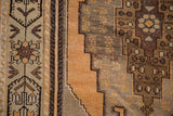 Stepped geometric patterns and distressed texture of a vintage Oushak rug in bronze and grey.