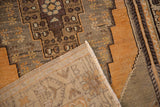 Folded corner of vintage distressed Oushak rug, showing stepped pattern pile and hand-knotted reverse.
