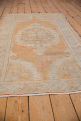 Distressed Oushak rug runner's time-softened tangerine, ivory, and silver tones with even pile wear.