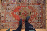 Vintage Oushak rug with abrashed field, central medallion, and warm rust and pale blue colors.
