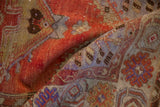 Vintage Oushak rug folded, showing abrashed rust, pale blue, and coffee brown motifs.
