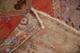 Vintage Oushak rug showing hand knotted foundation, mostly even worn pile, and fringe.