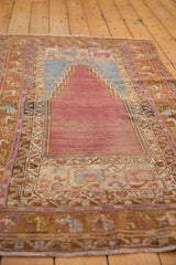 Lengthwise view of a distressed Turkish Oushak rug showing its stepped prayer niche.