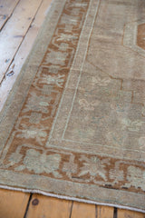 Detail of vintage Distressed Oushak rug, showing worn pile, beige, and pale bronze border patterns.