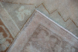 Distressed Oushak rug showing detailed foundation weave, side selvage, and even pile wear.