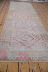 Distressed pink, blush, and pale blue geometric patterns with worn texture on vintage Oushak runner.