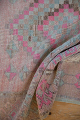 Distressed vintage Oushak rug texture, showing even wear in pink, blush, and soft blue.