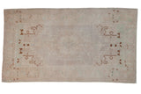 Distressed vintage Oushak rug with a tone-on-tone medallion and bronze vinery on an ivory field.