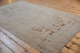 Low pile texture and even wear on a distressed Oushak rug with bronze and seafoam green tones.