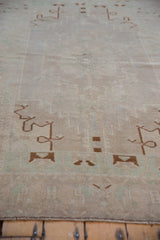 Angled view across the distressed Oushak's surface, showing the even wear and soft texture.