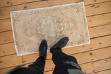 Vintage Distressed Oushak rug mat with muted beige, ivory, and mint floral medallion.