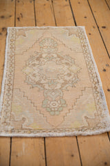 Distressed vintage Oushak rug lower corner, revealing faded fringe and stepped pattern border.
