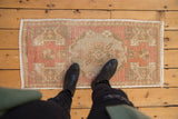 Distressed Oushak mat runner, traditional faded dusty rose floral design, underfoot.