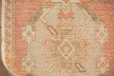 Distressed hand-knotted Oushak rug pile texture showing dusty rose and beige wear.