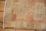 Distressed Oushak rug corner showing even wear across knot heads and intact side selvage.