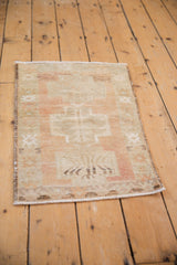 Textured distressed pile of vintage Oushak rug with beige, sand, and pale blush geometric motifs.