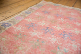 Distressed pink Oushak runner with faded floral pattern and distinct patterned border.