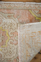 Vintage Turkish Oushak rug detail: worn ivory, peach pile revealing foundation, with woven reverse.