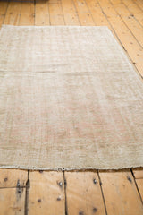 Distressed vintage Oushak rug pile with muted beige, dusty rose, and faint scrolling vinery.