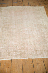 Distressed hand knotted Oushak rug featuring soft rose and beige hues, showcasing worn texture.