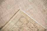 Distressed Oushak pile in pink, dusty rose, and beige, showing its hand-knotted foundation.