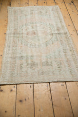 Vintage Distressed Oushak rug, pile reveals pale rose and blue vine motifs.