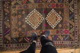 Distressed Oushak rug's worn pile revealing fuchsia, purple, indigo, and beige patterns.