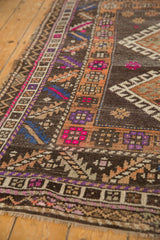 Distressed vintage Oushak rug: hook-and-latch motif, serrated leaves, and bright fuchsia accents.