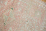 Distressed hand-knotted Oushak rug pile showcasing soft pink, ivory, and subtle silver hues.