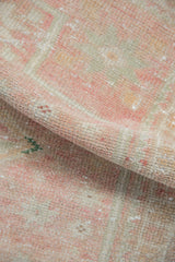 Distressed Oushak rug pile with even wear, faint foundation, pink, rose, and ivory tones.