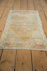 Distressed vintage Oushak rug with faded central medallion in muted gold and soft rust.