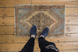Distressed Oushak rug mat, bold stepped medallion, softened colors on low pile.