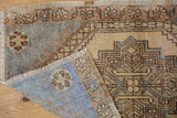Distressed slate blue Oushak rug pile revealing faint foundation, with striped woven back.